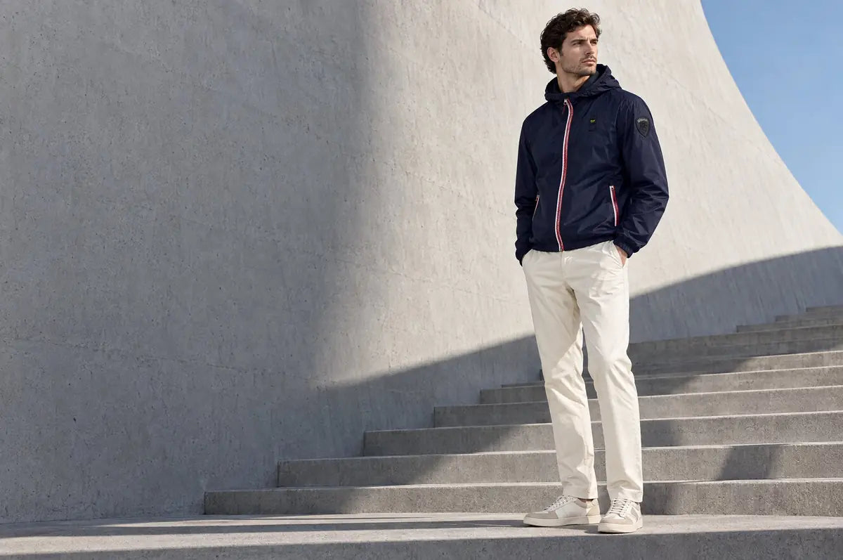 Uomo con giacca a vento blu navy su una scalinata in cemento